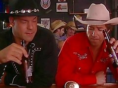 Two hot cowbays drinking beer in a gay bar
